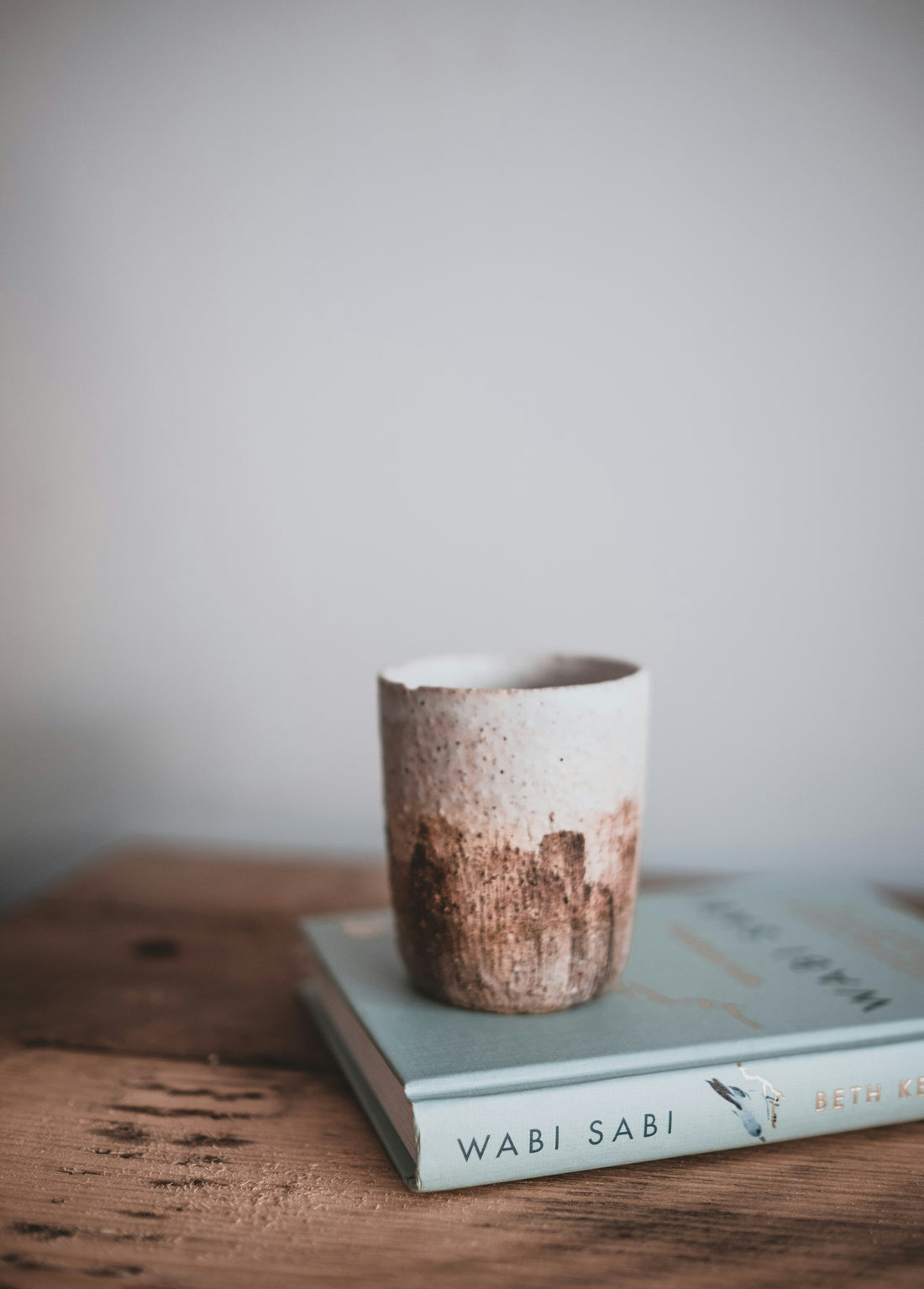 Cup on a Wabi Sabi book with white wall